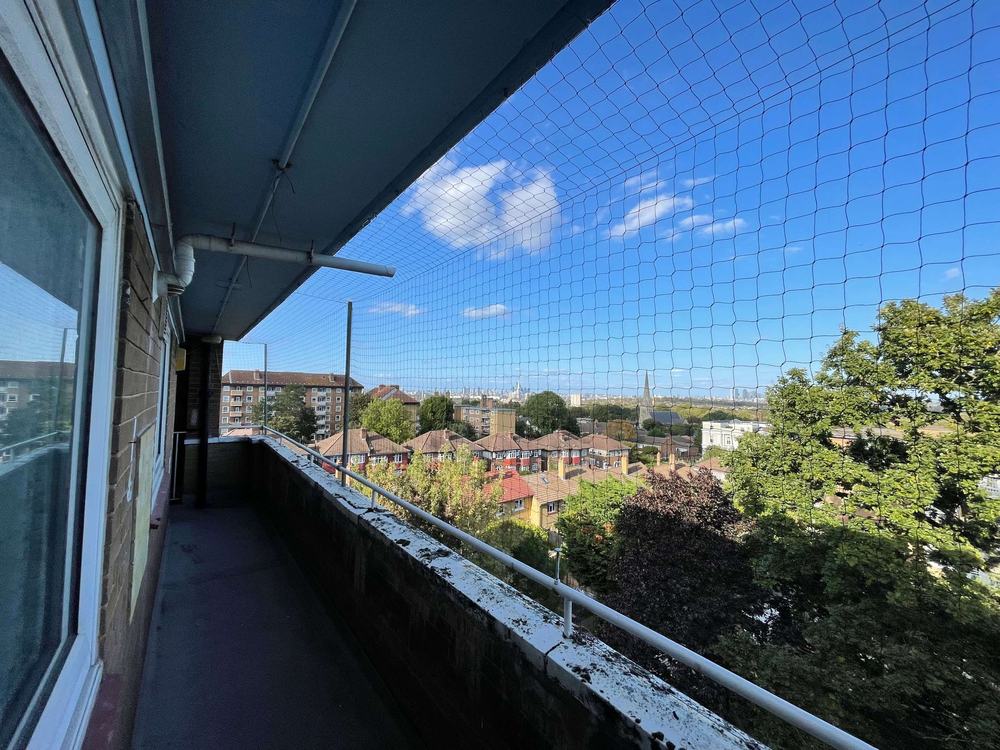 Bird netting along a long walkway on a block of flats